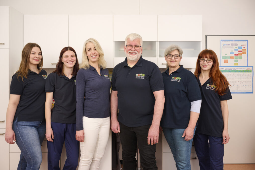 Teamfoto des Tierarztpersonals mit einem Deutschen Schäferhund.